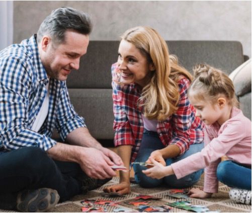 El coronavirus nos obliga a volver a ser familia - Padres haciendo puzzle con su hija - International Montessori School en Sotogrande, Cádiz