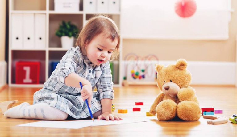 ¿Es el método Montessori correcto para mi hijo:a? - Niña pintando en el suelo con peluche - International Montessori School en Sotogrande, Cádiz