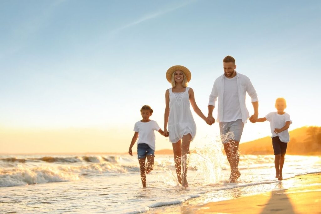 Family walking on beach at sunset - Relocating to Spain with your family 